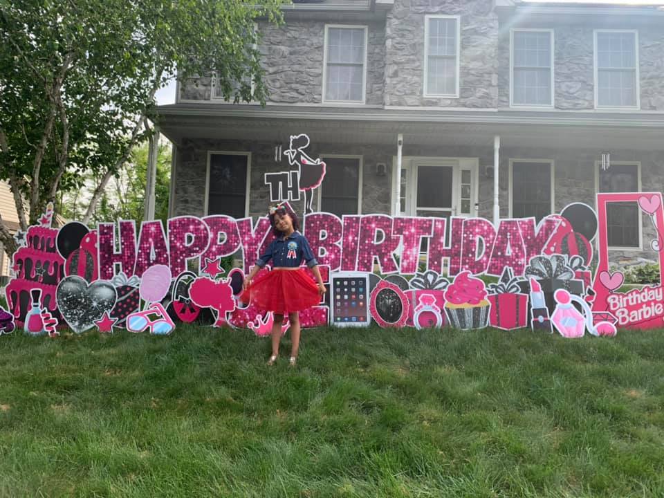 happy birthday custom yard sign with a little girl standing in front of it in bowie, md