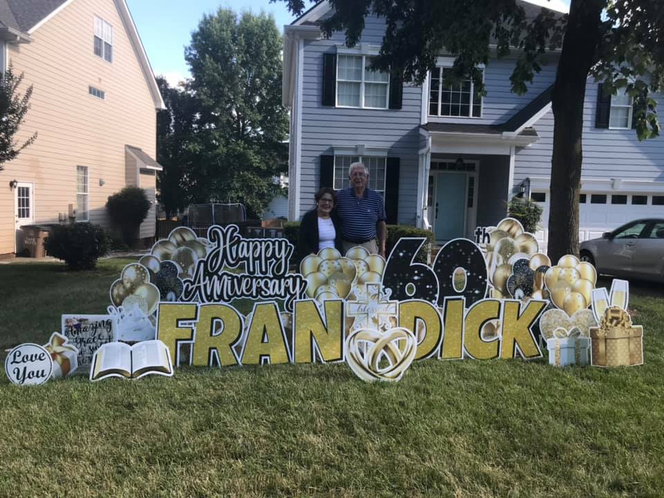 a picture of a couple standing behind a 60th anniversary celebratory yard sign for a couple in Bowie, MD